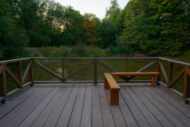 istock patio with a fence and a bench overlooking a small pond on a summer evening 1044040174