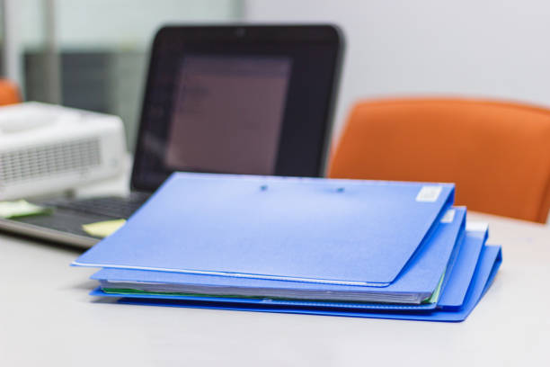 istock Blue file folder with documents and Notebook in meeting room 1044043296