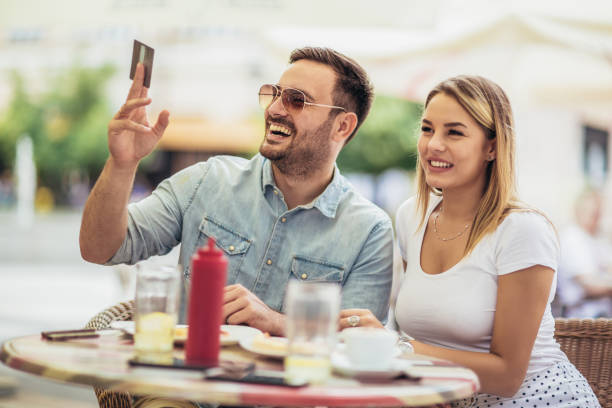 istock Pay the bill. Attractive young couple holding credit card while siting in sidewalk cafe. 1044043542