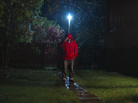 Long exposure blurred motion night shot of a man under rain