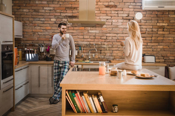 istock Happy couple communicating while drinking morning coffee in the kitchen. 1044050632