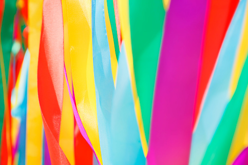 Multicolored silk ribbons are heard in the wind. Background image. Soft focus