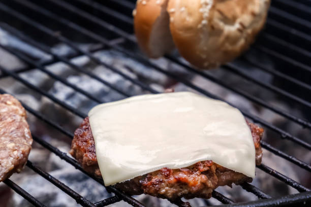 istock Cooking cheeseburger on hot coals with smoke 1044053110