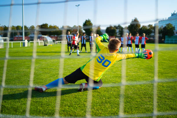 младший футбольный матч вратарь в действии - playing field kids soccer goalie soccer player стоковые фото и изображения