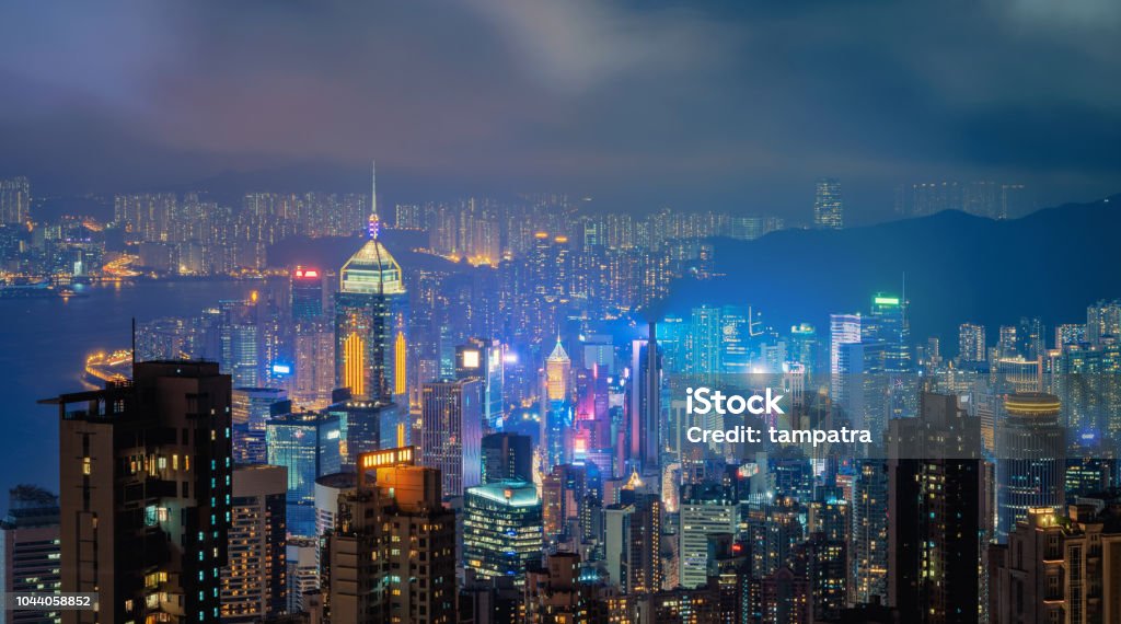 Hong Kong centro y puerto de Victoria. Distrito financiero de ciudad inteligente. Rascacielos y altos edificios. Vista aérea en la noche. - Foto de stock de Hong Kong libre de derechos