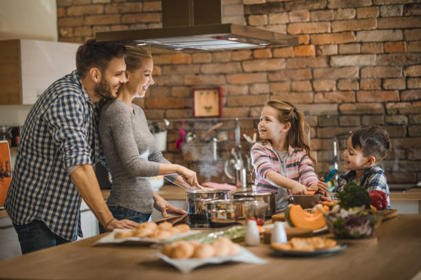 istock Happy family cooperating while making lunch in the kitchen. 1044058996