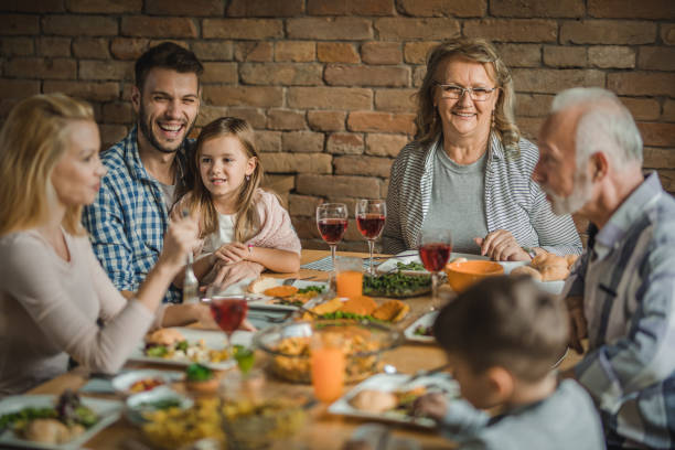 istock Happy multi-generation family sitting at dining table and talking during lunch time. 1044060412