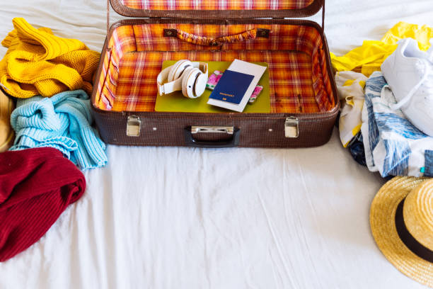 istock suitcase with winter and summer clothes on bed. preparing for trip. suitcase with garment. travel concept 1044062016