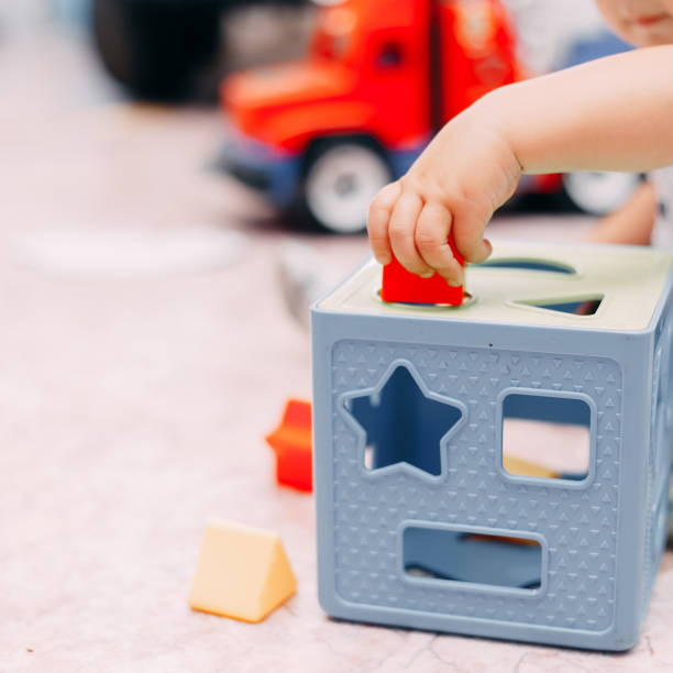 istock Toddler kid solves sorter puzzle block at home 1044065428