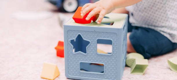 Toddler kid solves sorter puzzle block at home