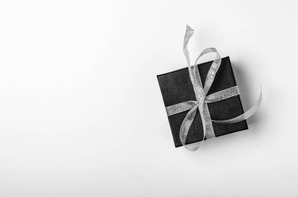 Gift black box with silver ribbon on white background. Top view, copy space.