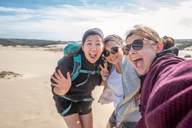 Multi-Ethnic Mother and Daughters Taking Selfie on Dunes, Oregon, USA