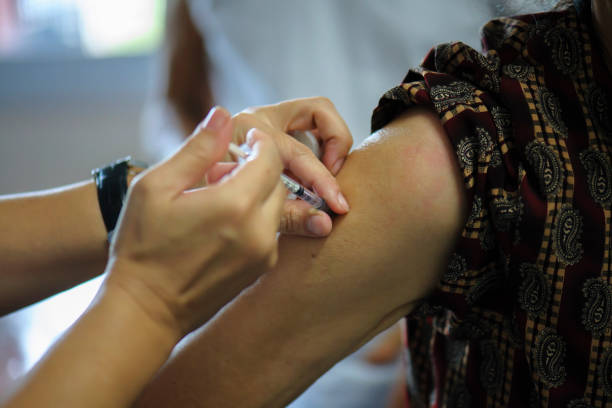 istock Getting flu vaccines from a doctor with an injection in the arm. 1044079606