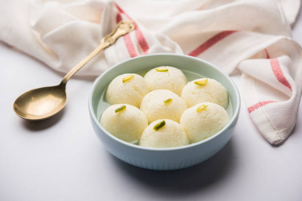Indian Rasgulla or Rosogulla dessert/sweet served in a bowl. selective focus Indian Rasgulla or Rosogulla dessert/sweet served in a bowl. selective focus rosogolla stock pictures, royalty-free photos & images