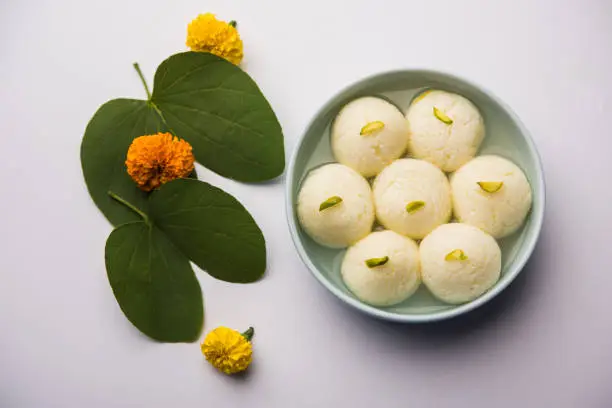 Happy Dussehra / Vijayadashami / Ayudh Puja greeting card using apta/Bauhinia racemosa/Bidi leaf and indian sweet Rasgulla for Navaratri