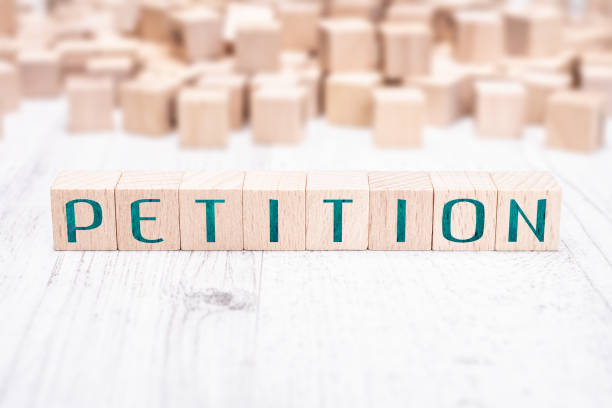 The Word Petition Formed By Wooden Blocks On A White Table stock photo