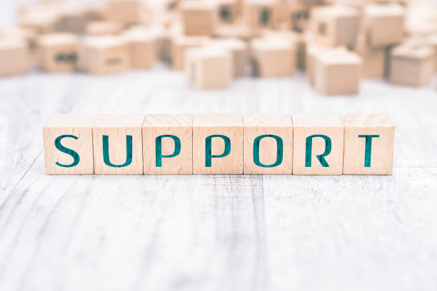 The Word Support Formed By Wooden Blocks On A White Table The Word Support Formed By Wooden Blocks On White Table help single word stock pictures, royalty-free photos & images