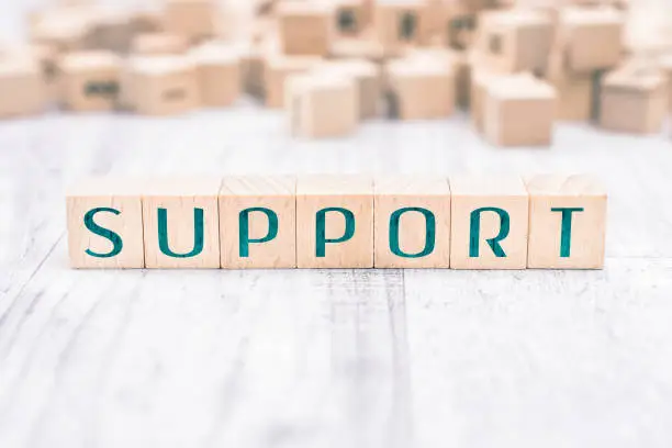 The Word Support Formed By Wooden Blocks On White Table