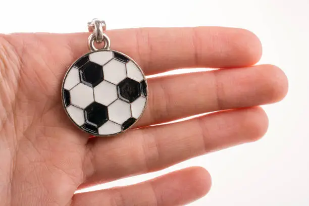 Football shaped keyholder in hand on a white background