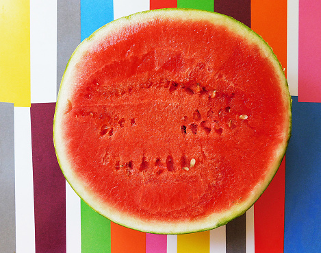A half of fresh watermelon isolated on colorful background.