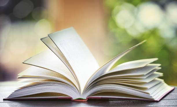 istock Breeze blows pages of open book on outdoor table 1044097410