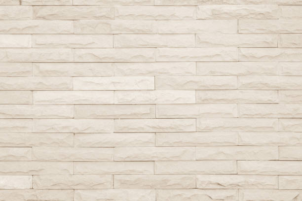 istock Seamless Cream pattern of decorative brick sandstone wall surface with concrete of modern style design decorative uneven have cracked realmasonry wall of multicolored stones or blocks with cement. 1044100018