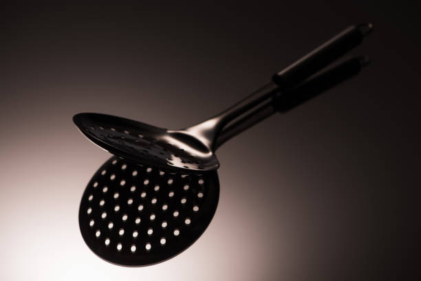 istock close-up view of single black colander reflected on grey 1044109880
