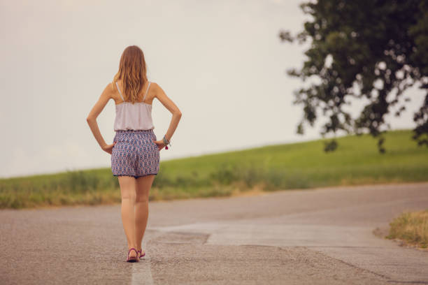 Girl walking on a empty suburb road.