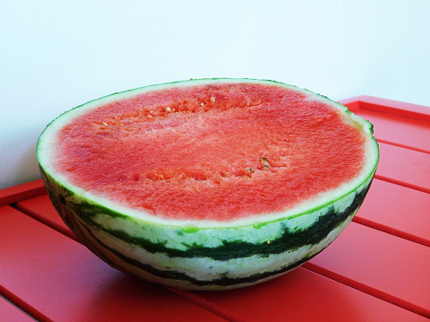 A half of watermelon on red table