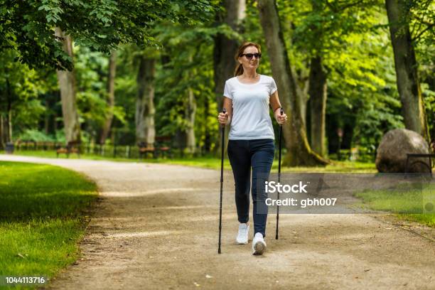 Mitte Gealterte Frau Nordic Walking Im Stadtpark Stockfoto und mehr Bilder von Gehen - Gehen, Sportwandern, Frühling