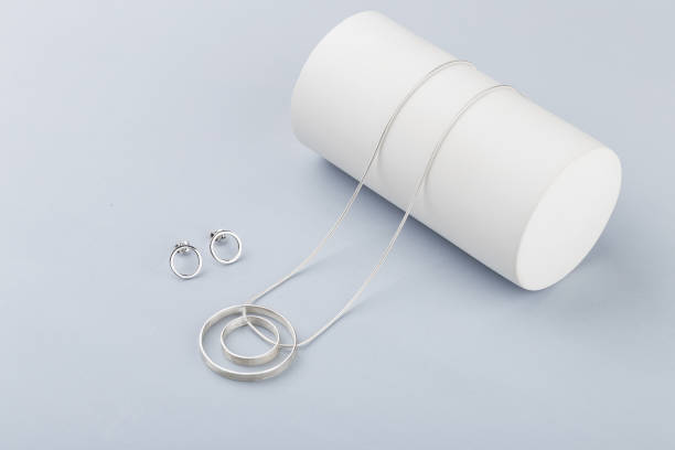 istock Minimalist geometric silver necklace and circle stud earrings on gray background 1044115688