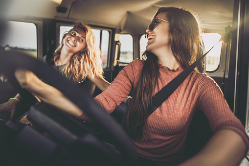 Young happy women communicating while having fun on their road trip.