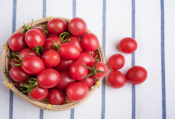 muchos tomates cherry envasados cesta de bambú - vegetable basket fotografías e imágenes de stock