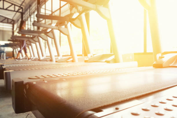 Sport gym trainning background, focus on treadmill with  morning light.