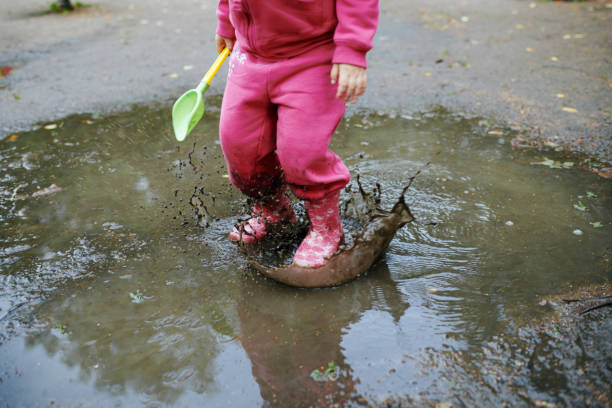 istock Child jumps in a dirty puddle 1044123310
