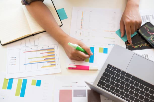 istock analytics financial data with top view hand of business working with paper chart. 1044127292