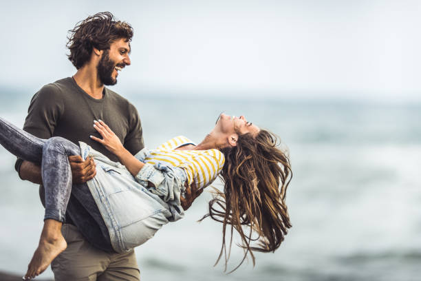 istock Joyful couple having fun together on the beach. 1044127810