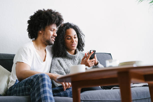 istock Young beautiful couple on sofa using smartphone 1044141144