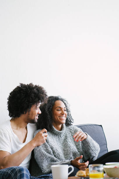 istock Young beautiful couple on sofa using smartphone 1044141170