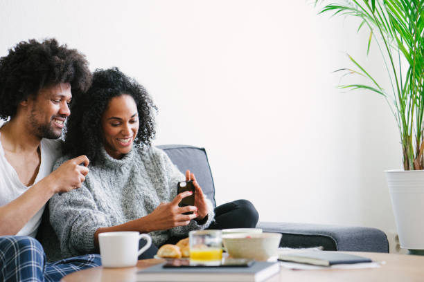 istock Young beautiful couple on sofa using smartphone 1044141240