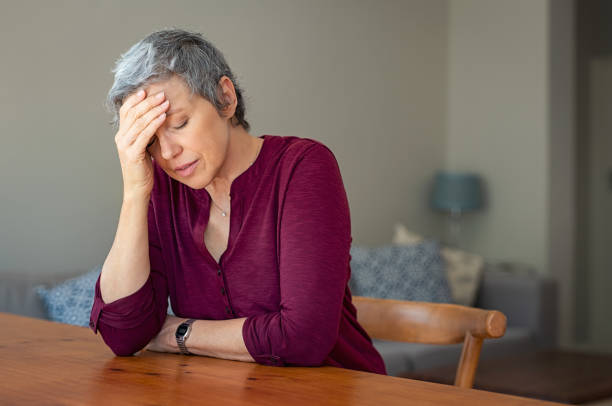 mujer senior estresada en casa - menopausia fotos fotografías e imágenes de stock