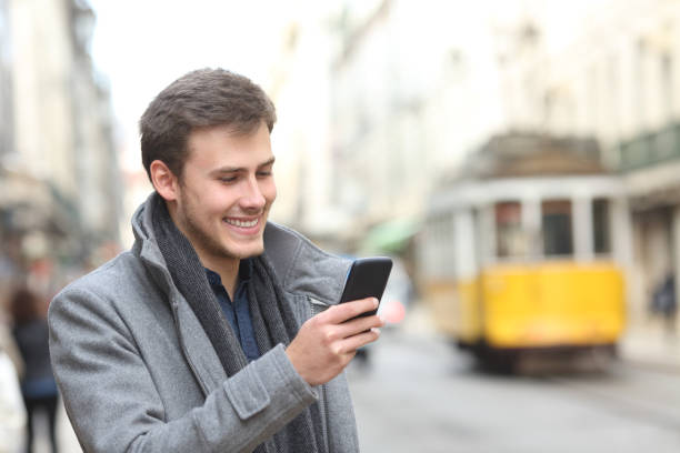 istock Man uses a smart phone in a city old town 1044154068