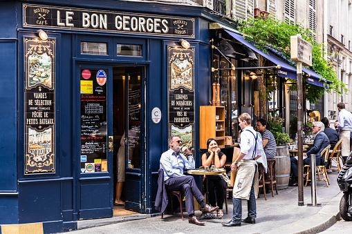 Paris, France - June 16, 2017: The charming Cafe Le Bon Georges. Parisians and tourists enjoy food and drinks at the street french cafe.