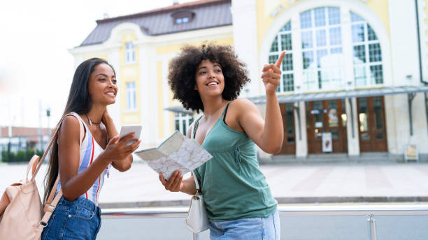 istock Friends using a map and mobile phone on station 1044166180