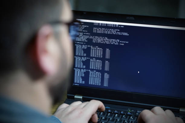 hacker à l’aide d’ordinateur portable. beaucoup de chiffres sur l’écran de l’ordinateur - cracking the code photos et images de collection