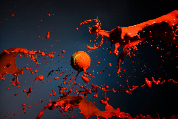 red paint splash and tennis ball on blue background - drink close up dairy product flowing imagens e fotografias de stock