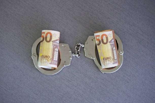 istock handcuffs on and twisted money. Top view. 1044177710