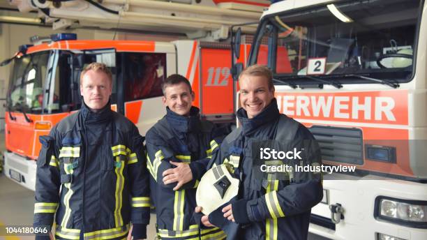 Gruppe Der Feuerwehr Am Einsatzfahrzeug Im Feuerwehrhaus Stockfoto und mehr Bilder von Feuerwehrmann