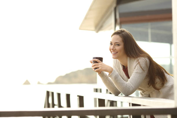 istock Happy hotel guest holding coffee looking at you 1044184404