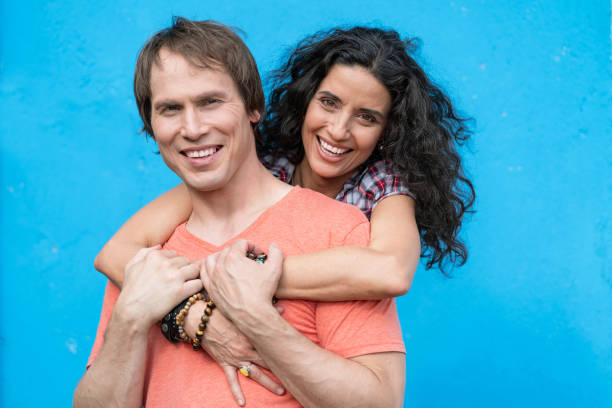 istock Mid adult couple embracing on blue background 1044185330